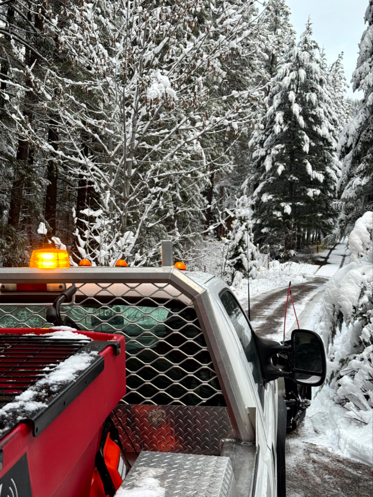 Snow removal truck clearing a snow-covered driveway in Leavenworth, WA